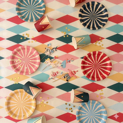 Kit de fiesta "El Gran Circo de Colores" con platos de rayas, vasos de domador y toppers de animales sobre mantel de rombos vintage.