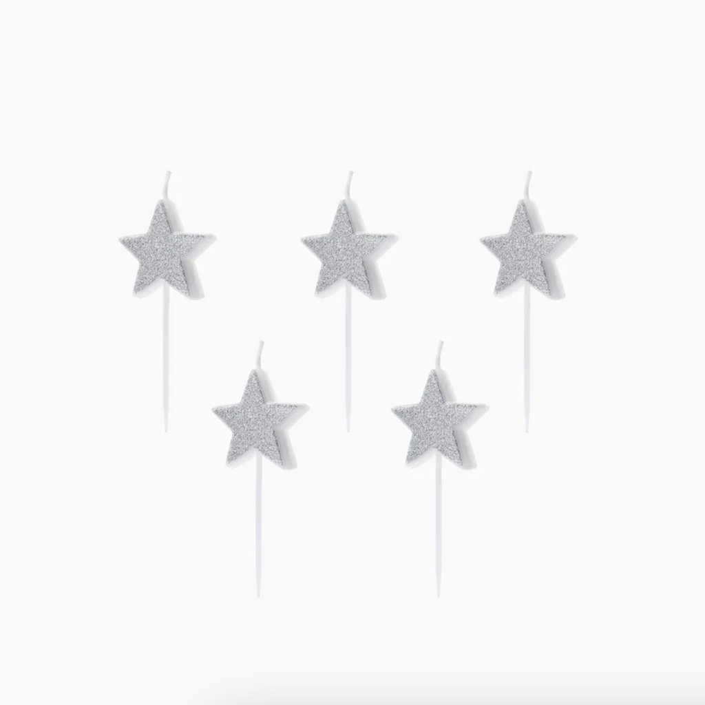 Velas de cumpleaños con forma de estrella y acabado brillante plateado sobre fondo blanco.