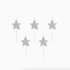 Velas de cumpleaños con forma de estrella y acabado brillante plateado sobre fondo blanco.