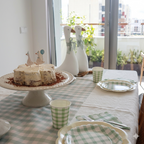 Tarta blanca con toppers de gansos ilustrados y platos coordinados en verde salvia y crema de la colección Silly Goose.